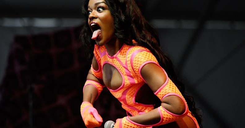 Azealia Banks poses while performing at the 2013 Governors Ball Music Festival in an orange dress