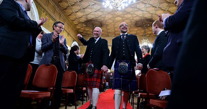 Joe Schofield and Malcolm Brown from Tullibody, Clackmannanshire are married by Ross Wright, Celebrant from Humanist Society Scotland in the Trades Hall shortly after midnight in front of friends and family in one of the first same-sex and belief category weddings in Scotland on December 31, 2014 in Glasgow, Scotland.