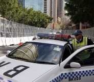 SYDNEY, AUSTRALIA - SEPTEMBER 06: A policeman gets into a police car, parked between security fences, on September 6, 2007 in Sydney, Australia. (Amos Aikman/Getty Images)