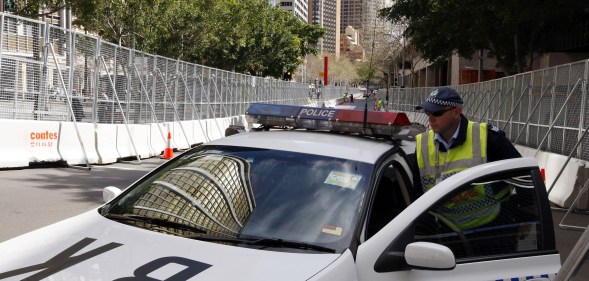 SYDNEY, AUSTRALIA - SEPTEMBER 06: A policeman gets into a police car, parked between security fences, on September 6, 2007 in Sydney, Australia. (Amos Aikman/Getty Images)