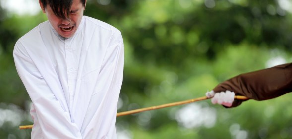 One of two Indonesian men is publicly caned for having sex, in a first for the Muslim-majority country where there are concerns over mounting hostility towards the small gay community, in Banda Aceh on May 23, 2017. (CHAIDEER MAHYUDDIN/AFP via Getty Images)