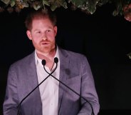 Prince Harry speaking into two microphones