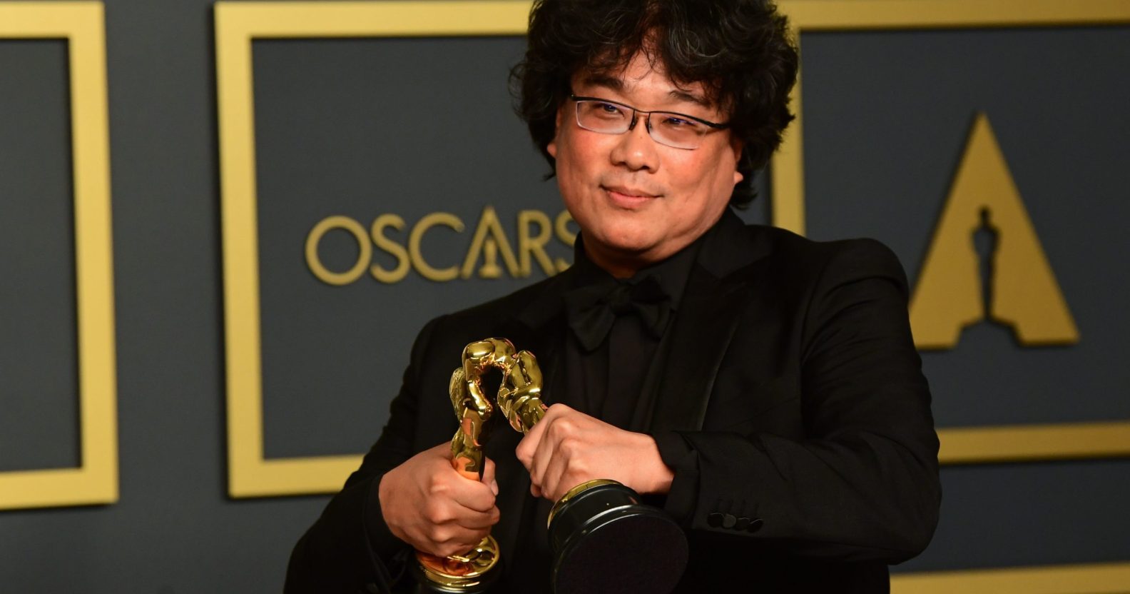 South Korean director Bong Joon-ho poses in the press room with the Oscars for Parasite