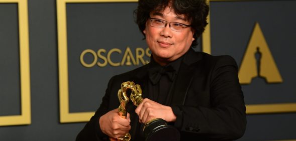 South Korean director Bong Joon-ho poses in the press room with the Oscars for Parasite