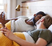Male Gay Couple Lying In Bed At Home Checking Mobile Phones Together coronavirus semen