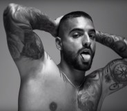 Maluma holding his hands behind his head, sticking his tongue out