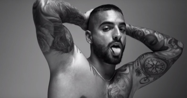 Maluma holding his hands behind his head, sticking his tongue out