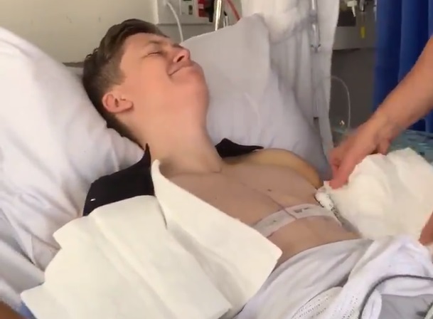 The powerful clip shows bandages being carefully removed in hospital after top surgery.