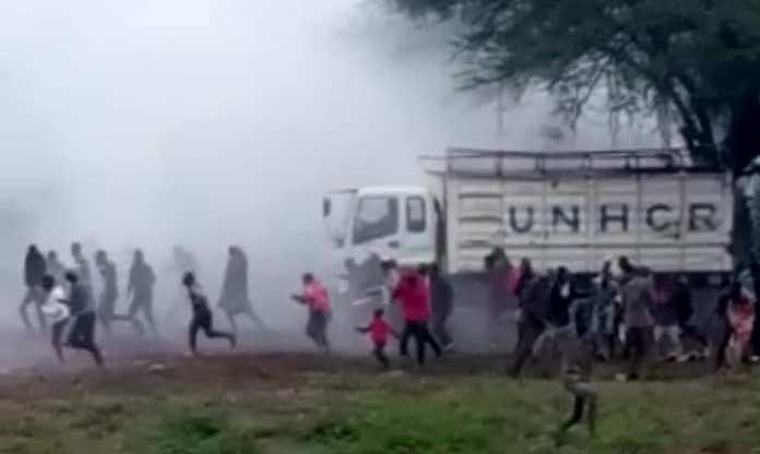 Harrowing footage seen by PinkNews shows Kakuma refugee camps sprinting as teargas engulfs them. Multiple nondescript bangs can be heard in the distance. (Screen capture via Facebook)