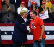 US president Donald Trump shakes hands with Minneapolis Police Union head Bob Kroll on stage during a campaign rally at the Target Center on October 10, 2019 in Minneapolis, Minnesota