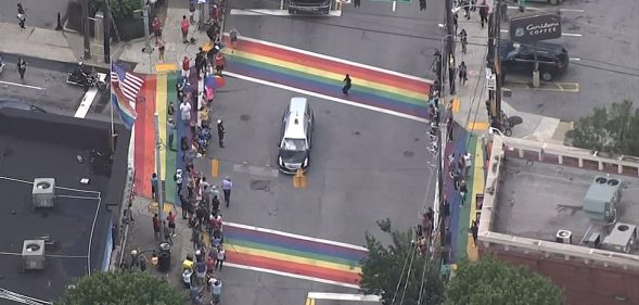 The casket of John Lewis, a towering giant in the civil rights movement, pauses as crowds cheer at a Pride flag-inspired crossroads in Atlanta, US. (Screen capture via Facebook)