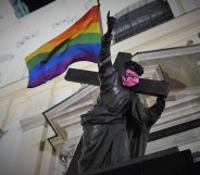 Statue of Jesus carrying Pride flag and wearing anarchist bandana