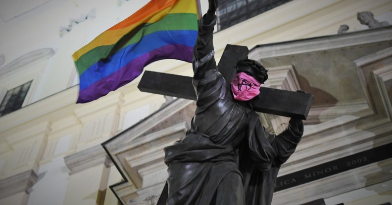 Statue of Jesus carrying Pride flag and wearing anarchist bandana