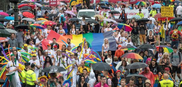 People hold placards and rainbow flags during a Pride event in Czech capital Prague on August 10, 2019