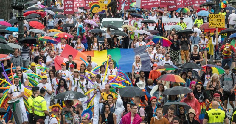 People hold placards and rainbow flags during a Pride event in Czech capital Prague on August 10, 2019