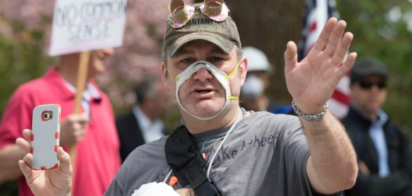 Man wearing a face mask cut out so that his mouth is exposed