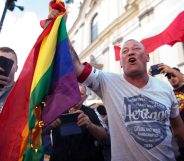 A man burns a LGBT flag during the anniversary of Warsaw Uprising in Warsaw, Poland
