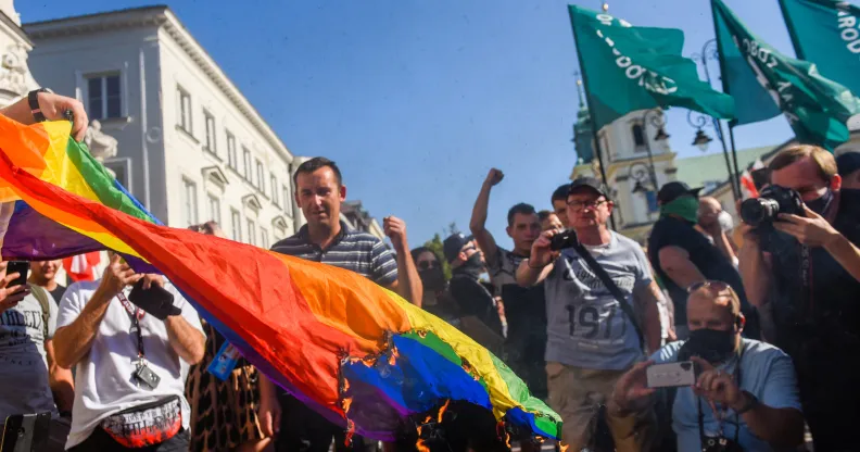 Far-right protesters attempt to burn a rainbow flag as they protest against the LGBT community on August 16, 2020 in Warsaw, Poland.