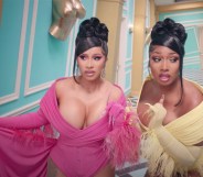 Cardi B and Megan Thee Stallion walking down a twist Alice in Wonderland-style corridor in gowns in the WAP video