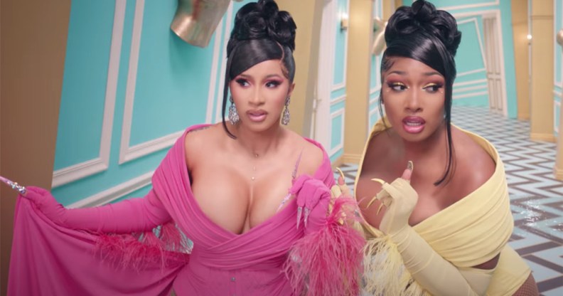 Cardi B and Megan Thee Stallion walking down a twist Alice in Wonderland-style corridor in gowns in the WAP video