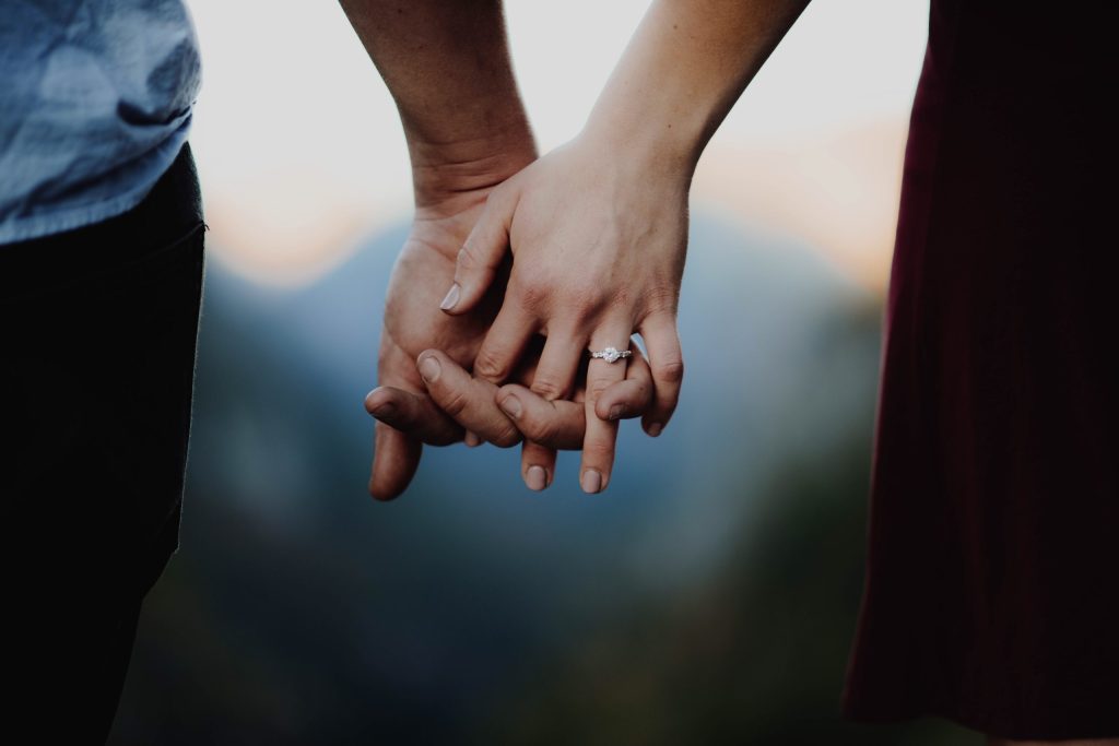 A close-up image of two people holding hands