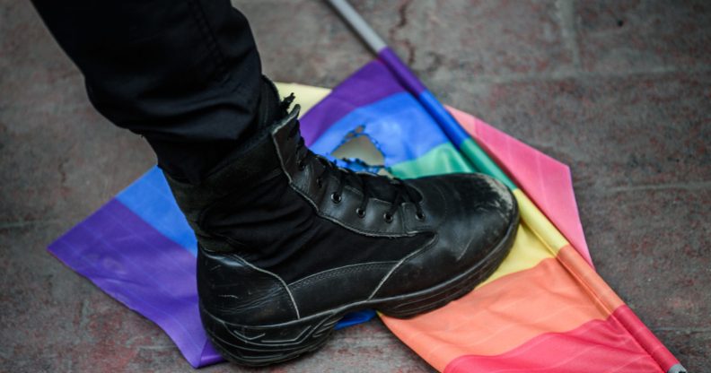 A Turkish anti-riot police officer steps on a rainbow flag during a rally staged by the LGBT community on Istiklal avenue in Istanbul on June 19, 2016. (OZAN KOSE/AFP via Getty Images)