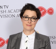 A photo of TV presenter Sue Perkins wearing a white shirt and silver grey suit jacket as she smiles to the camera during the British Academy Television Awards