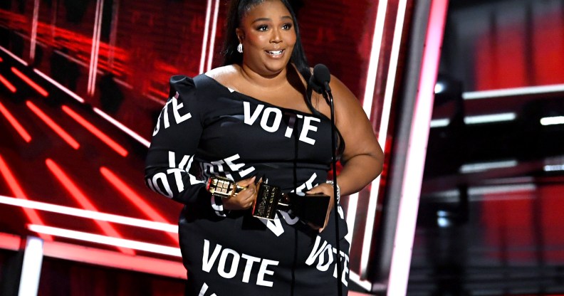 Lizzo in a black dress with the word VOTE in bold white text all over