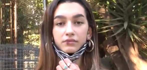 Eva Vidosola pulling down her face mask to reveal a bloodied lip