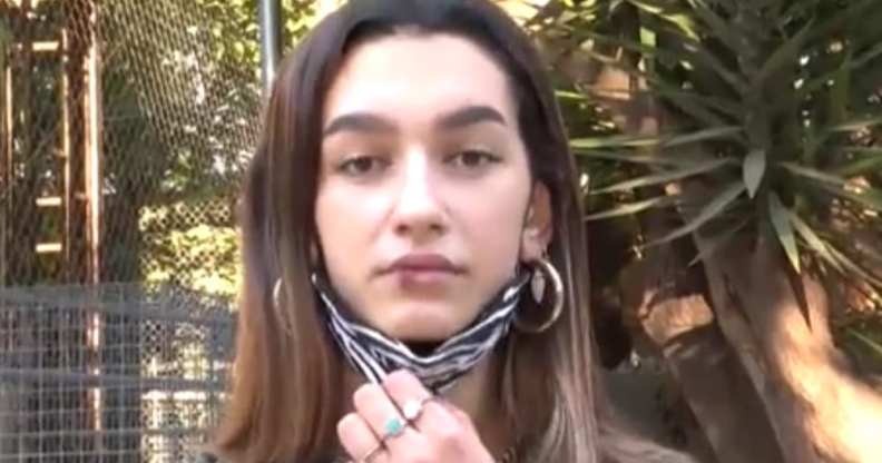 Eva Vidosola pulling down her face mask to reveal a bloodied lip