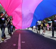 People marching with anBi, a bisexual organization, carry a bisexual flag in the LA Pride Parade