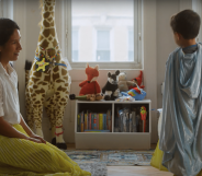 Kiran wearing a yellow princess dress as his mother kneels next to him in a matching yellow skirt