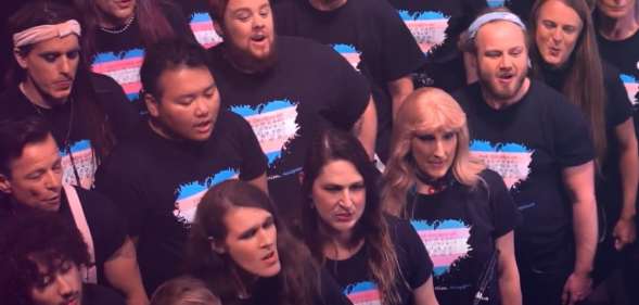 Choir members wearing t-shirts with a heart on in the colours of the trans flag
