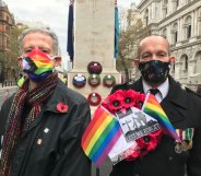 Peter Tatchell and David Bonney holding a rainbow poppy wreath at the Cenotaph