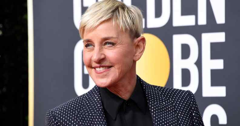 Ellen DeGeneres smile while wearing a grey suit jacket