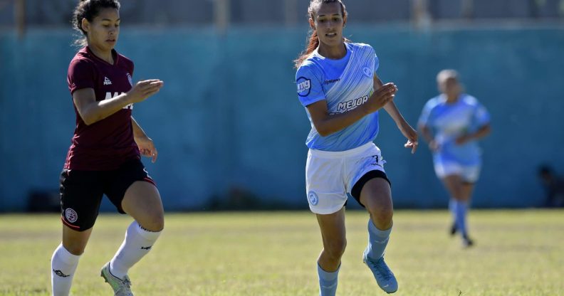 Transgender footballer Mara Gomez of Villa San Carlos vies for the ball with Luciana Nievas of Lanus