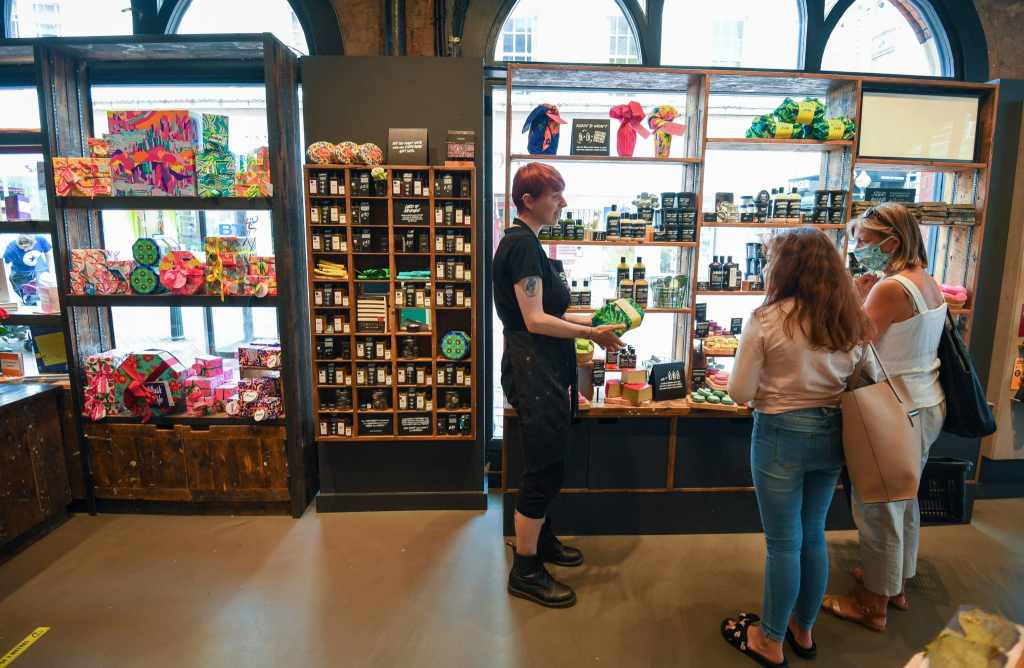 People wearing protective face masks shop in Lush in Bournemouth in June2020