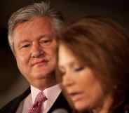 Marcus Bachmann wears a suit and red tie