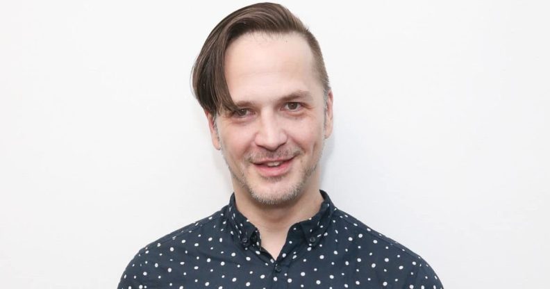 Michael Alig in a printed blue shirt against a white background