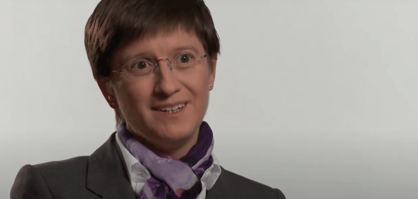 Julia Hoggett wearing a suit against a white backdrop