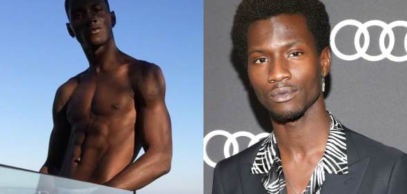 Adonis Bosso topless standing against a skyline, a glass pane hiding his lower section