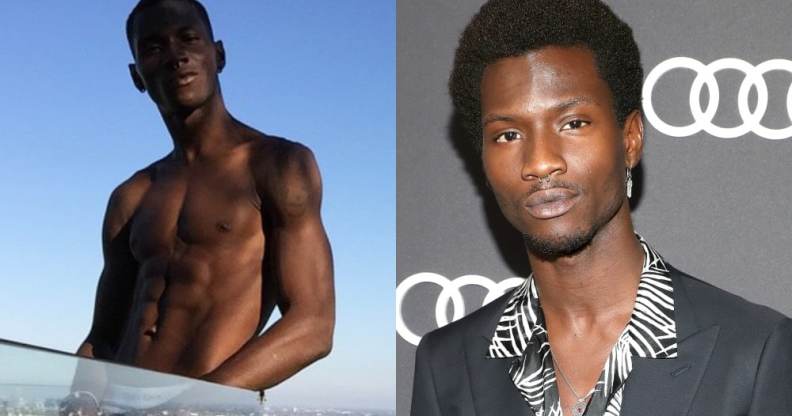 Adonis Bosso topless standing against a skyline, a glass pane hiding his lower section