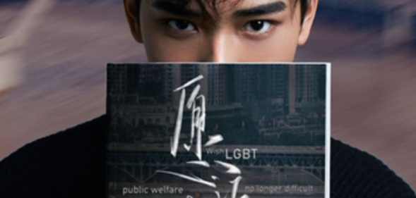 A photo of a man holding a book to his face which reads: 'Wish LGBT public welfare no longer difficult'