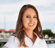zzy Wouters in a white shirt standing on the docks