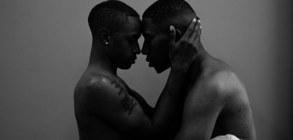 Two Black men about to kiss