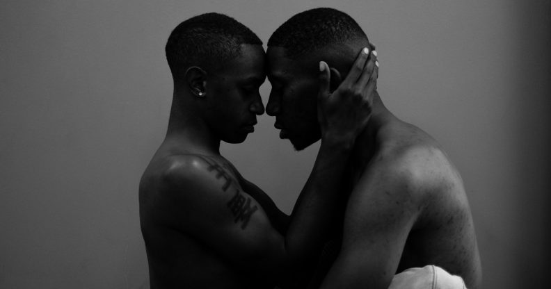 Two Black men about to kiss