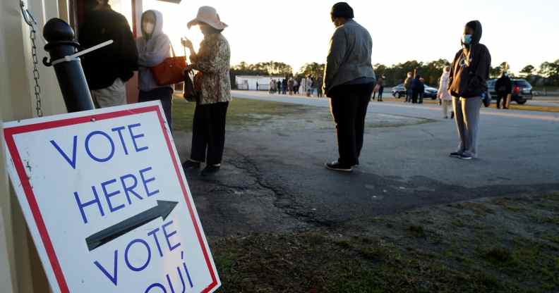 Voters stand in line to cast their ballots during the first day of early voting in the US Senate Georgia run-off elections