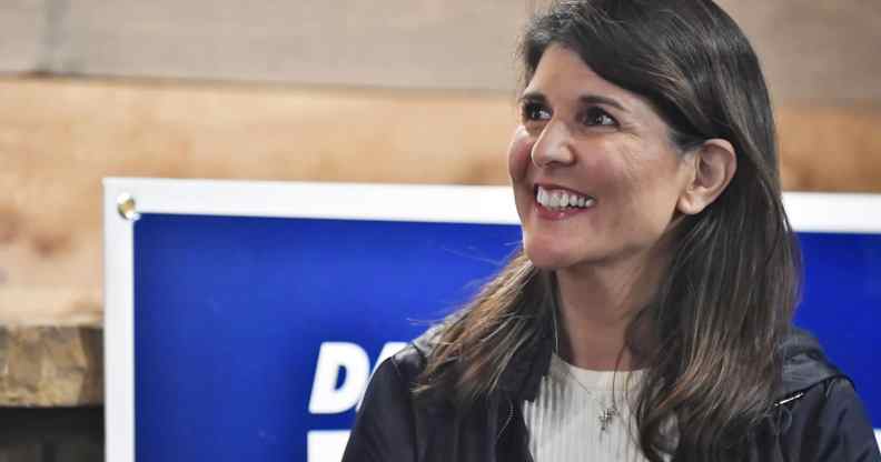 Nikki Haley smiles in a white ribbed top and black jacket