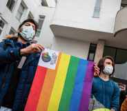 Demonstrators wearing masks hold an LGBT+ flag during the demonstration at Boaziçi University, Istanbul, Turkey