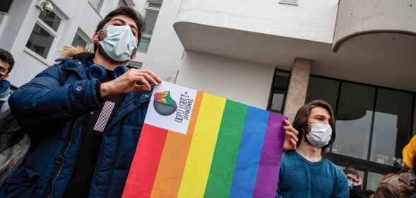 Demonstrators wearing masks hold an LGBT+ flag during the demonstration at Boaziçi University, Istanbul, Turkey